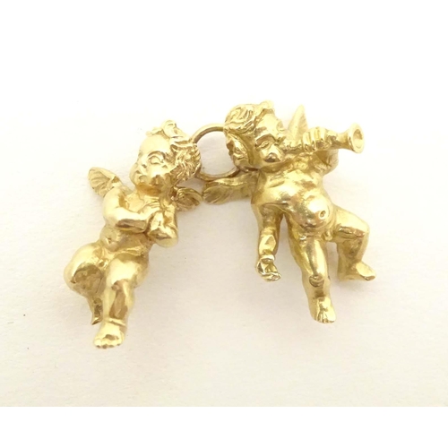 676 - An 18ct gold pendant / charm formed as two cherubs / angels. Approx. 1