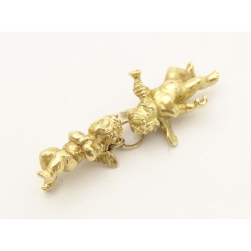 676 - An 18ct gold pendant / charm formed as two cherubs / angels. Approx. 1