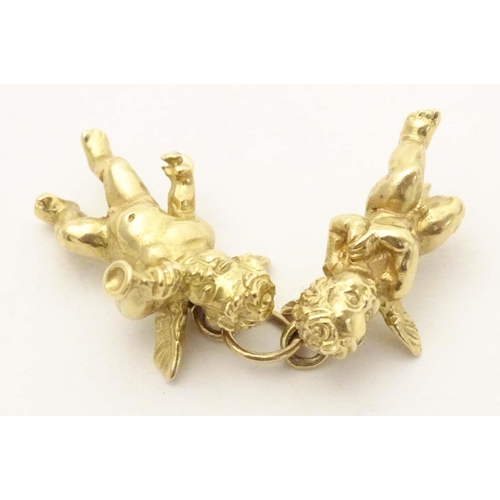 676 - An 18ct gold pendant / charm formed as two cherubs / angels. Approx. 1