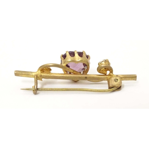 680 - A gilt metal bar brooch set with central amethyst coloured heart shaped stone to centre flanked by t... 