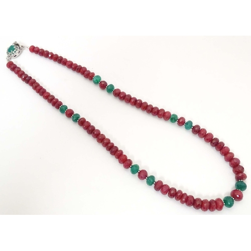 689 - A silver necklace set with various facet cut ruby and emerald beads. Approx. 18