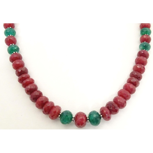 689 - A silver necklace set with various facet cut ruby and emerald beads. Approx. 18