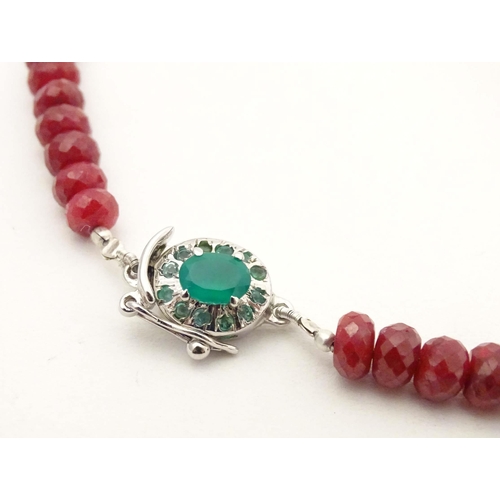 689 - A silver necklace set with various facet cut ruby and emerald beads. Approx. 18