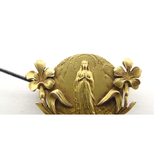 690 - An early 20thC Continental gilt metal brooch depicting the Virgin Mary to centre flanked by floral d... 