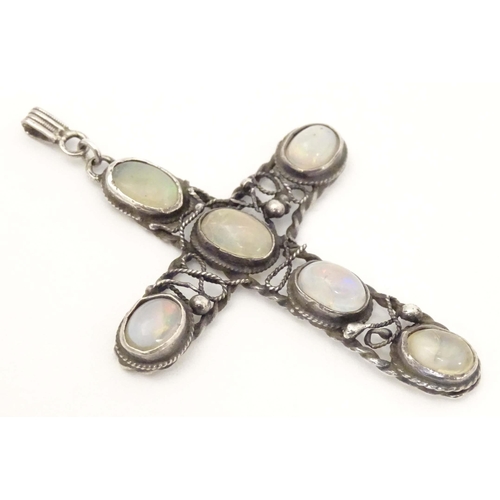 691 - An Arts & Crafts style white metal pendant of cross form set with six water opal style cabochon. App... 