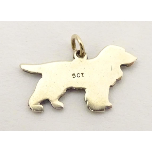 692 - A 9ct gold pendant charm formed as a spaniel dog with enamel detail. Approx. 3/4