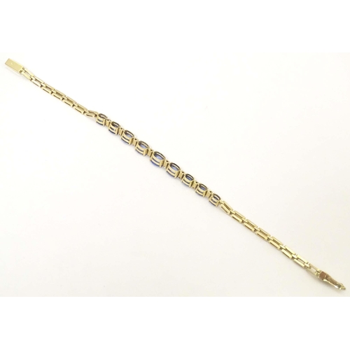 693 - An 18ct gold bracelet set with 9 facet cut topaz and 8 diamonds. Approx. 7