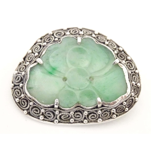 695 - An Oriental brooch with carved jade detail within a silver mount. Approx. 1 3/4