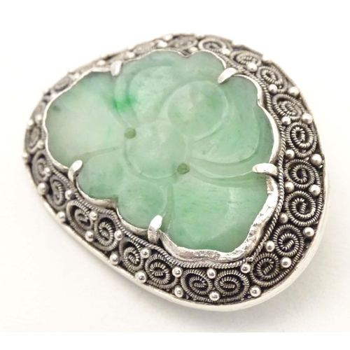 695 - An Oriental brooch with carved jade detail within a silver mount. Approx. 1 3/4