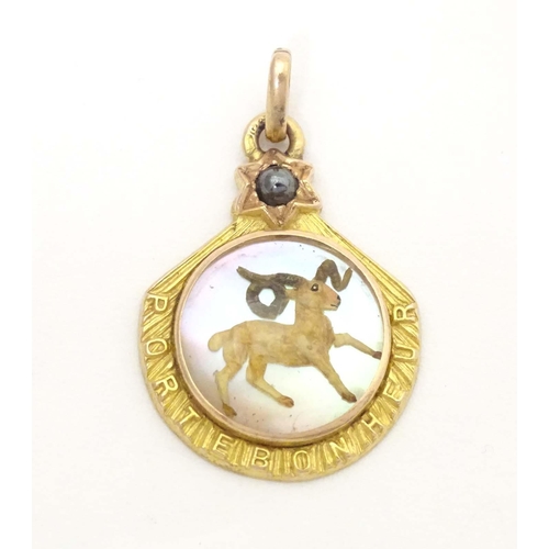 696 - A c.1900 French gold pendant / lucky charm set with Essex crystal style cabochon to centre depicting... 