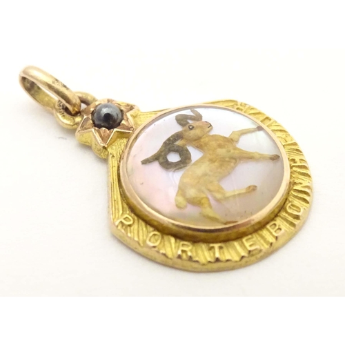 696 - A c.1900 French gold pendant / lucky charm set with Essex crystal style cabochon to centre depicting... 