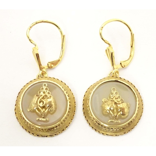 697 - A pair of gold and gilt metal drop earrings set with central chalcedony roundels with applied grape ... 