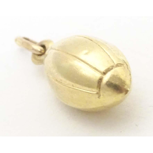 698 - A 9ct gold and gilt metal novelty pendant / charm formed as a rugby ball. Approx. 1