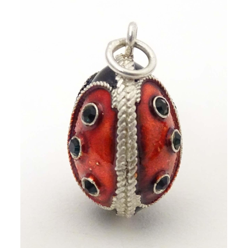 706 - A white metal pendant charm of egg form with stylised ladybird / ladybug detail with enamel detail. ... 