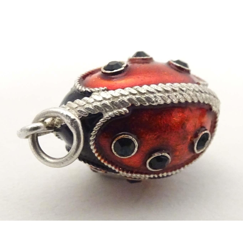 706 - A white metal pendant charm of egg form with stylised ladybird / ladybug detail with enamel detail. ... 