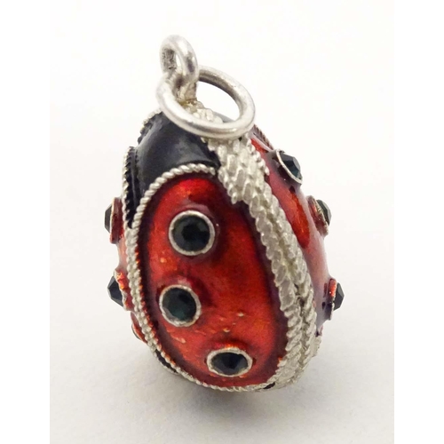 706 - A white metal pendant charm of egg form with stylised ladybird / ladybug detail with enamel detail. ... 