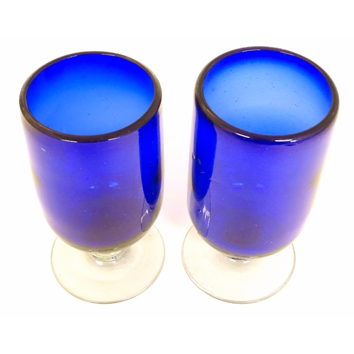 283 - Two Bristol blue style pedestal vases / glasses on a clear glass foot. The tallest approx 6 1/2