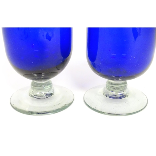 283 - Two Bristol blue style pedestal vases / glasses on a clear glass foot. The tallest approx 6 1/2