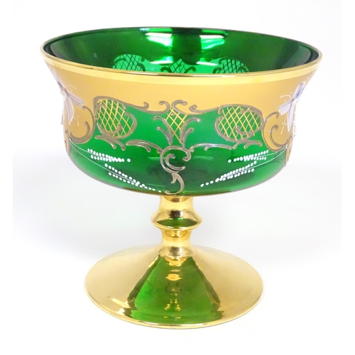 284 - A Bohemian green glass pedestal bowl with gilt and enamel floral detail. Approx. 7