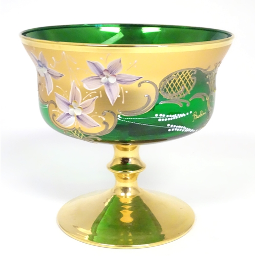 284 - A Bohemian green glass pedestal bowl with gilt and enamel floral detail. Approx. 7