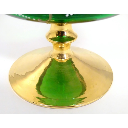 284 - A Bohemian green glass pedestal bowl with gilt and enamel floral detail. Approx. 7