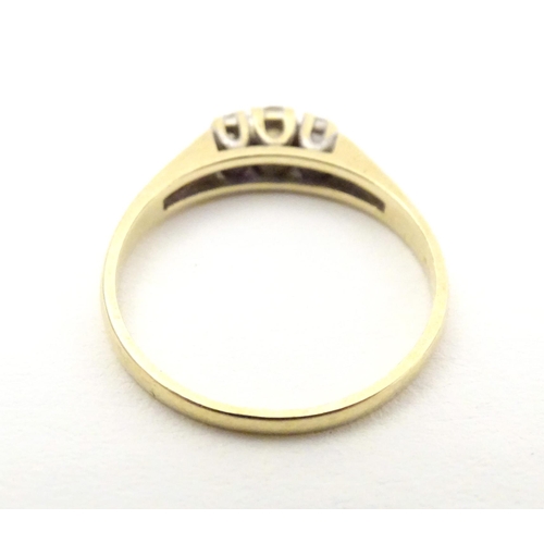 563 - A 9ct gold ring set with trio of diamonds. Ring size approx N.