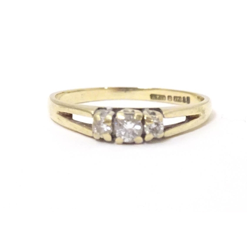 563 - A 9ct gold ring set with trio of diamonds. Ring size approx N.