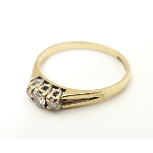 563 - A 9ct gold ring set with trio of diamonds. Ring size approx N.