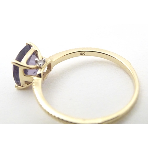 565 - A 9ct gold ring set with blueberry quartz to centre. Ring size approx R