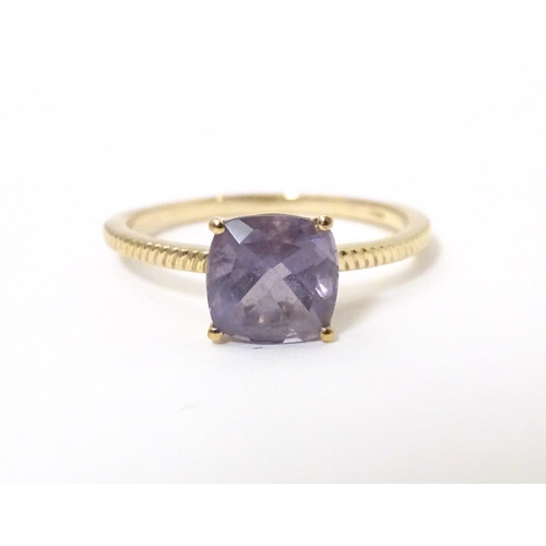 565 - A 9ct gold ring set with blueberry quartz to centre. Ring size approx R