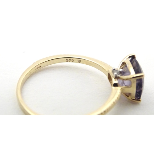 565 - A 9ct gold ring set with blueberry quartz to centre. Ring size approx R