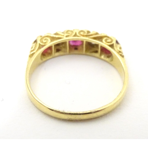 570 - An 18ct gold ring set with diamonds and rubies in a linear setting. Ring size approx. U 1/2