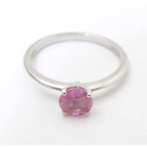 573 - A platinum ring set with pink sapphire solitaire. Ring size approx. O