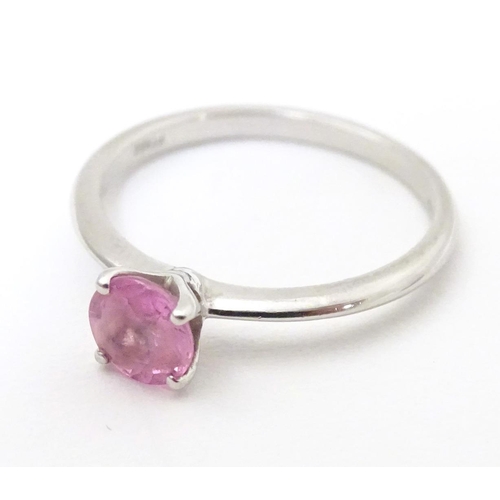 573 - A platinum ring set with pink sapphire solitaire. Ring size approx. O