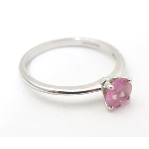 573 - A platinum ring set with pink sapphire solitaire. Ring size approx. O