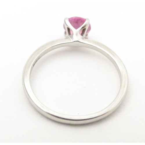 573 - A platinum ring set with pink sapphire solitaire. Ring size approx. O