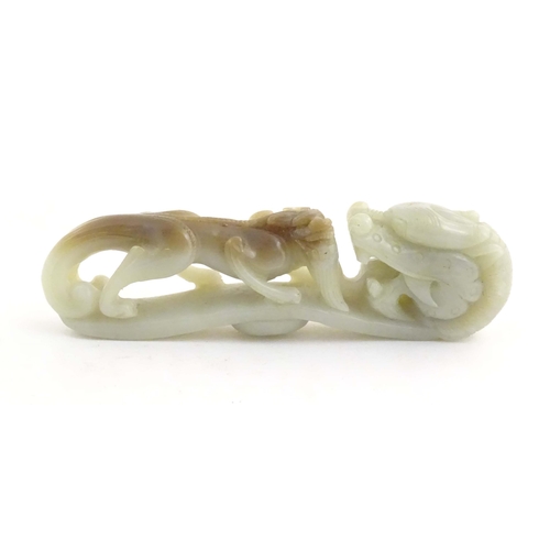 1025 - A Chinese hardstone belt hook style carving depicting a dragon head and creature. Approx. 4 3/4