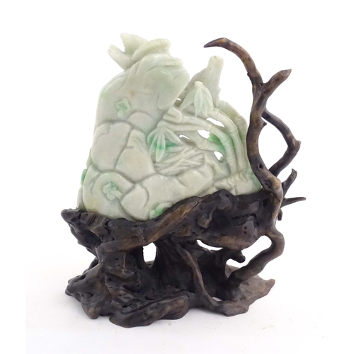 1027 - A Chinese light jade coloured hardstone 'boulder' carving depicting birds feeding chicks in a nest a... 