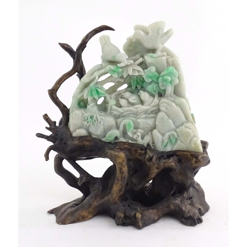 1027 - A Chinese light jade coloured hardstone 'boulder' carving depicting birds feeding chicks in a nest a... 