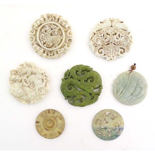 1029 - Seven assorted carved Oriental roundels / pendants, detail to include dragons, birds, stylised rams,... 