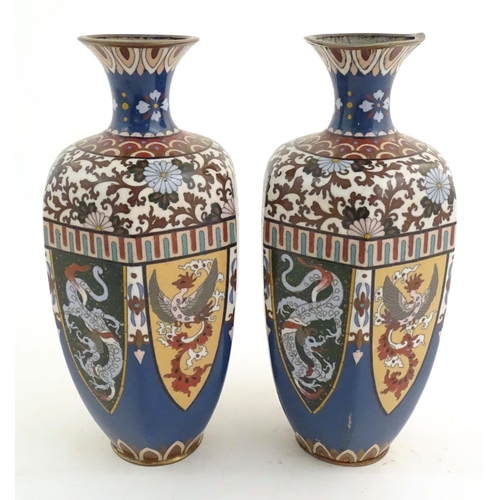 1031 - A pair of Oriental cloisonne vases decorated with panels of dragons and phoenix birds, the shoulders... 