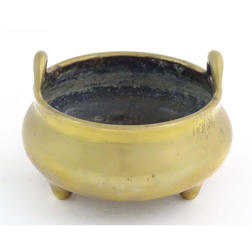 1048 - An Oriental three footed censer with twin handles. Character marked under. Approx. 5