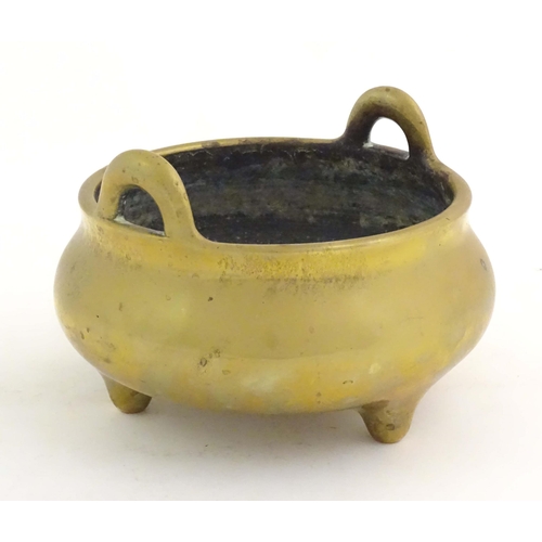 1048 - An Oriental three footed censer with twin handles. Character marked under. Approx. 5