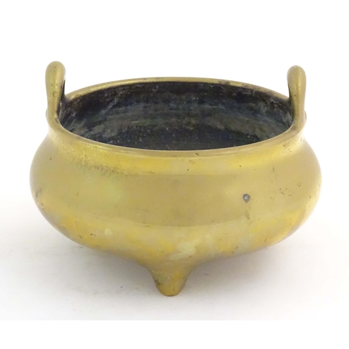 1048 - An Oriental three footed censer with twin handles. Character marked under. Approx. 5