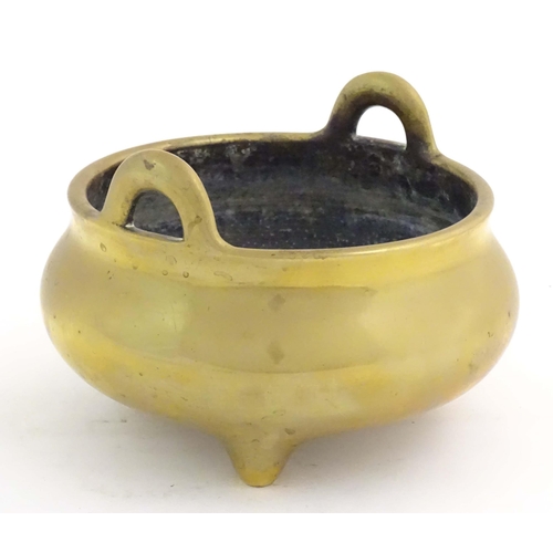 1048 - An Oriental three footed censer with twin handles. Character marked under. Approx. 5