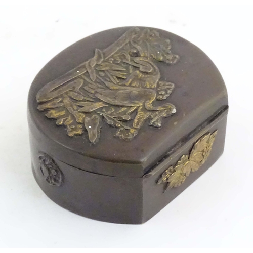 1051 - A Japanese lacquered brass stud box with a hinged lid, decorated with applied crane bird and floral ... 