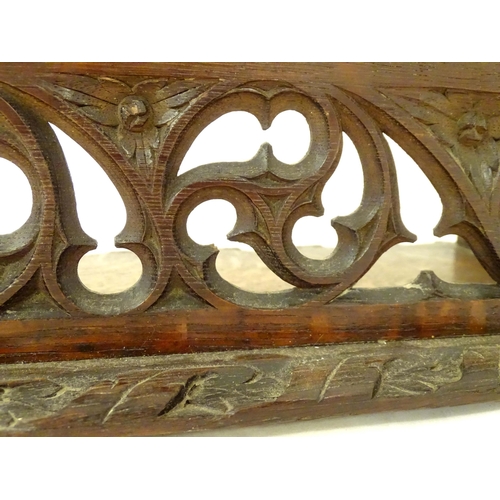 1264 - A 19thC carved oak Gothic book trough with lancet shaped uprights and carved foliate detail. Label u... 