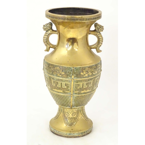 1279 - An Oriental cast brass vase of baluster form with twin foo dog handles, the body decorated with styl... 