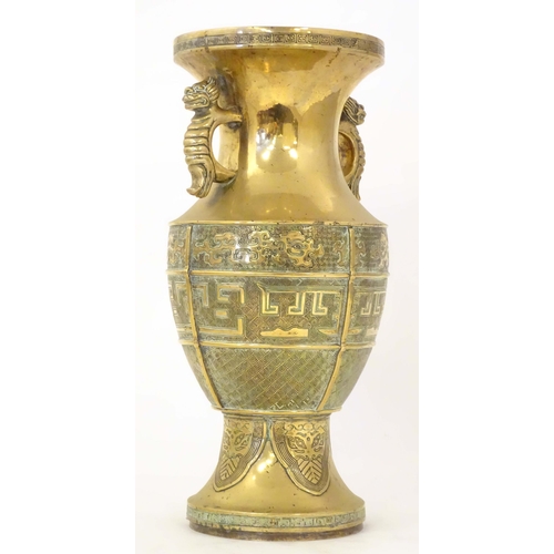 1279 - An Oriental cast brass vase of baluster form with twin foo dog handles, the body decorated with styl... 