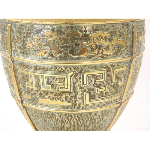 1279 - An Oriental cast brass vase of baluster form with twin foo dog handles, the body decorated with styl... 